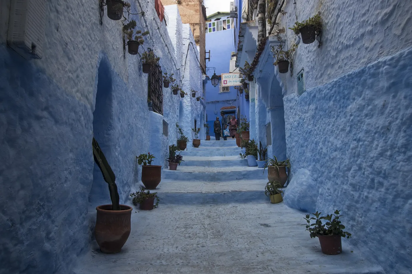 Blue-painted houses of Chefchaouen stacked on the hillside below the Rif Mountains in soft morning light