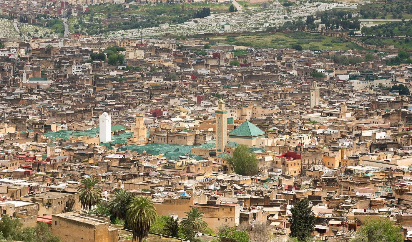 Chouara tannery in the Fes medina with rows of colourful dye pits seen from a leather shop terrace, Morocco