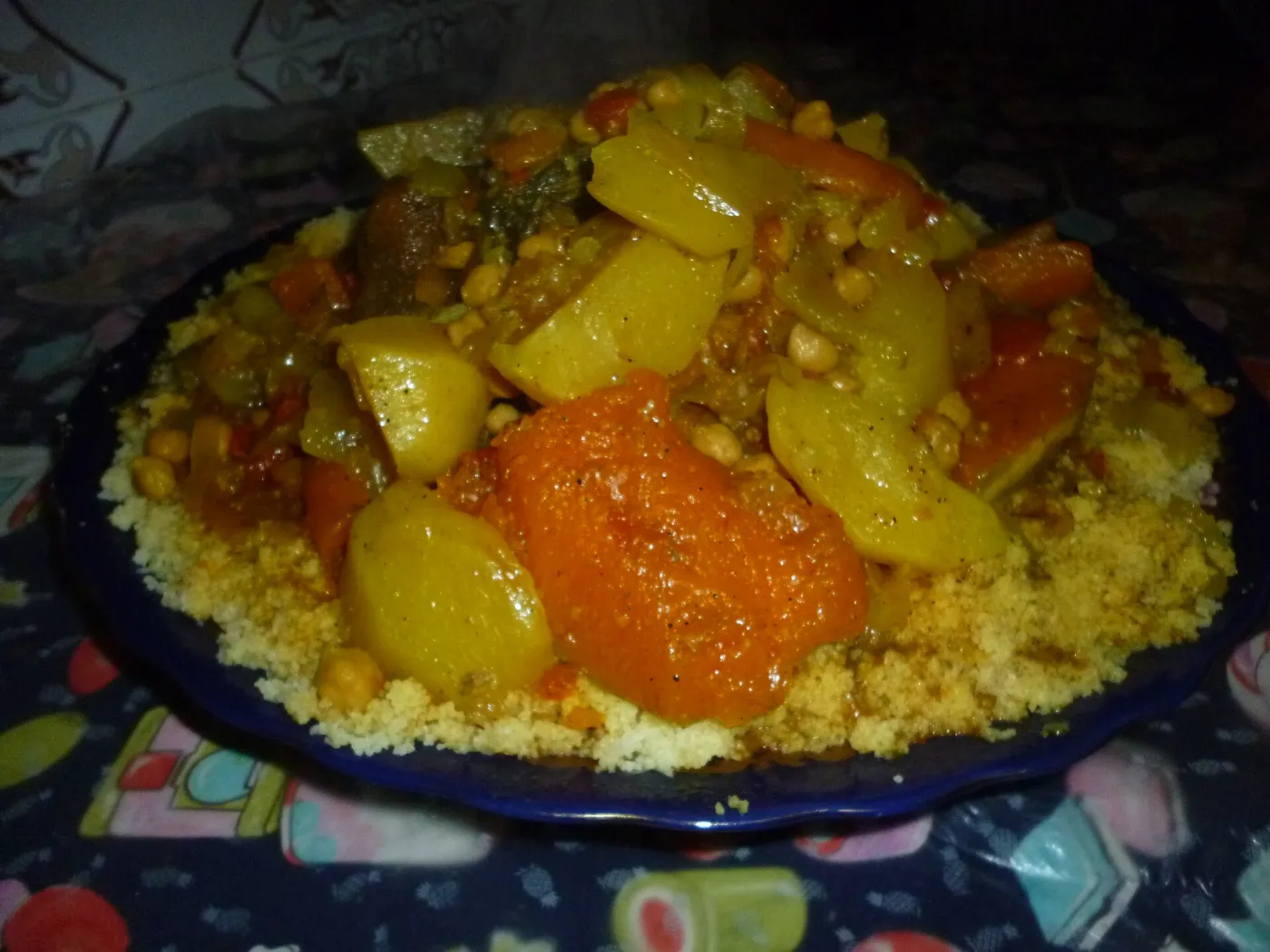 Table of traditional Moroccan dishes in Marrakech: a chicken tagine with preserved lemon and olives, couscous with vegetables, zaalouk and round khobz bread